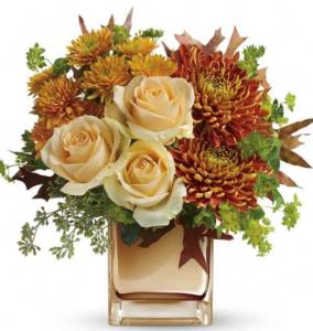 cream-colored roses with bronze colored mums in glass vase