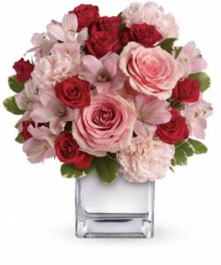 Lush pink and red roses, pink alstroemeria and pink carnations in a chic mirrored silver cube