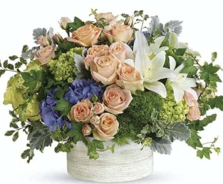 Intoxicating in its natural beauty, this wildly chic bouquet of pale peach roses and midnight purple hydrangea, arranged in a stylish white ceramic cylinder, is a breathtaking arrangement for any and all occasions.