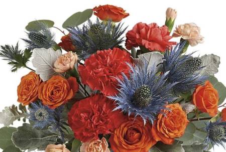 Tres chic! This high-fashion mix of bold orange roses and eye-catching blue eryngium, arranged in a frosted art glass vase, is a stand-out gift for any occasion!