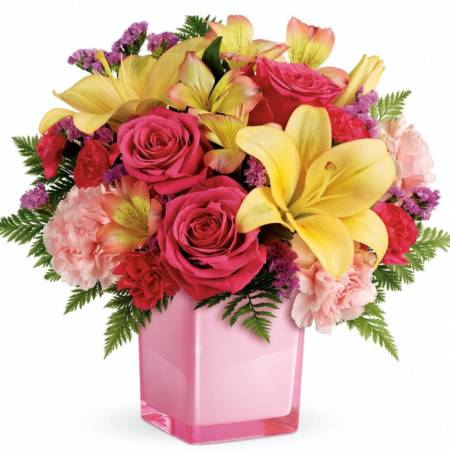 Turn up the fun! Make any day extra special with a surprise delivery of joyful blooms in a stylish cube vase. This bouquet of pink roses and luxurious peach lilies will make their mood soar!